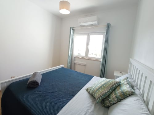 Quarto moderno na Sweet Home Inn Terrace em Portimão com cama de casal, vista para a cidade, ar condicionado e decoração minimalista