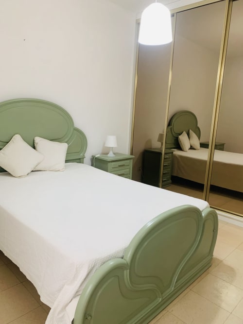 Quarto verde com roupa de cama branca e guarda-roupa espelhado no hotel Sweet Home, Portimão