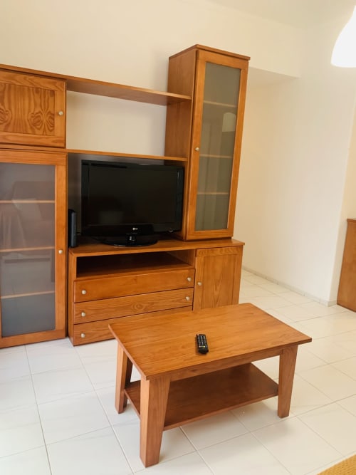 Unidade de TV em madeira com mesa de café na suíte do hotel Sweet Home, Portimão