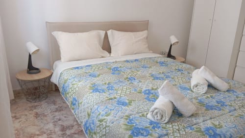 Quarto Orchid com roupa de cama floral, travesseiros brancos e toalhas dobradas no hotel Sweet Home em Portimão