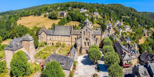 Aerial view of Aubazine village with historic monastery and stone buildings nestled in forested Limousin landscape