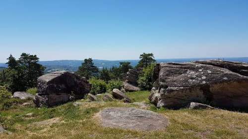 Rocky hilltop landscape near Aubazine with boulders, grass, and distant valley views