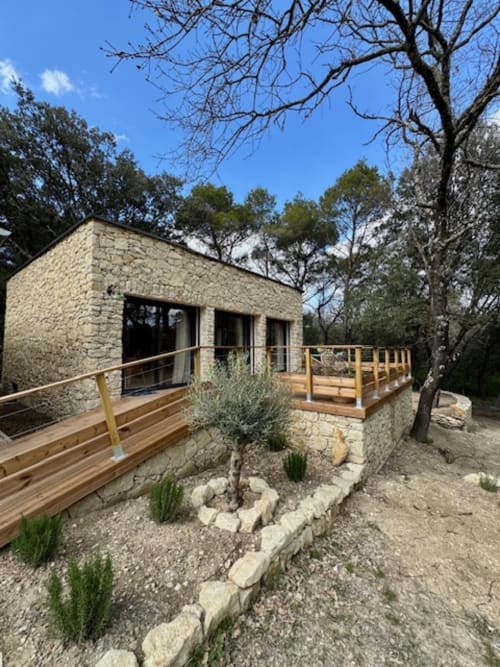 Suite en pierre moderne à Maison Terre de Lune à Mondragon avec terrasse bois, vue sur jardin et aménagement paysager résistant à la sécheresse