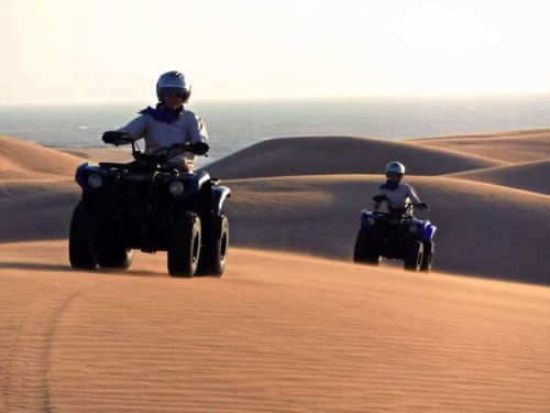 Deux motards explorent les dunes de sable du désert près du Riad Eucalyptus à El Ghazouane, Maroc