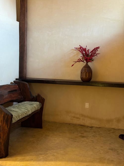 Habitación Sábalo minimalista en Ala Residencias, Chetumal, con silla de madera, flores rojas en florero y paredes amarillas