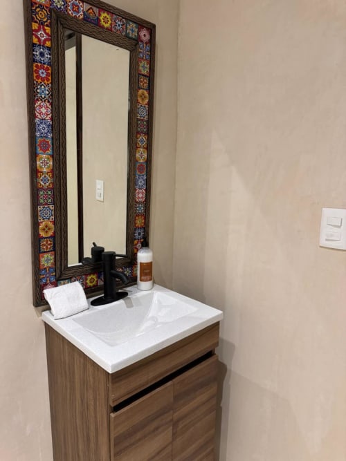 Lavamanos moderno en Ala Residencias, Chetumal, con espejo enmarcado en talavera colorida y lavabo blanco