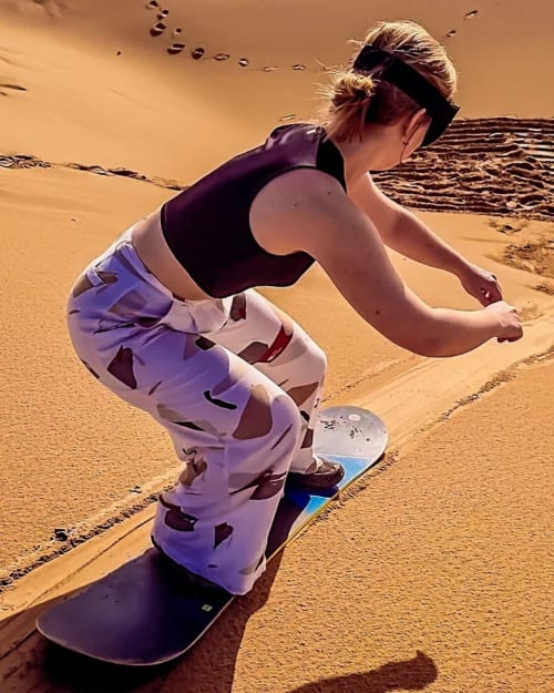 Femme en kitesurf sur la plage de sable près du Riad Eucalyptus à El Ghazouane, Maroc