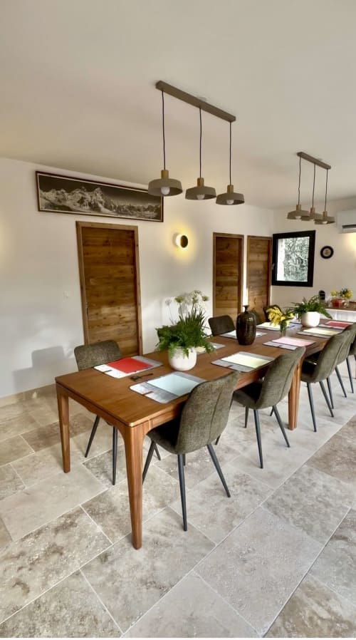Salle à manger contemporaine de Maison Terre de Lune avec table en bois, chaises grises, luminaires suspendus et plantes en pot