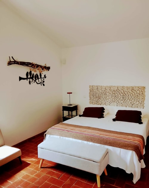 Quarto moderno na Quinta de Cerro da Campaniça em Santiago do Cacém com cama branca, detalhes em borgonha e arte eclética nas paredes