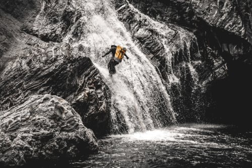 Adventurer rappelling down waterfall in Madeira, Portugal - outdoor activities near Check Madeira hotel