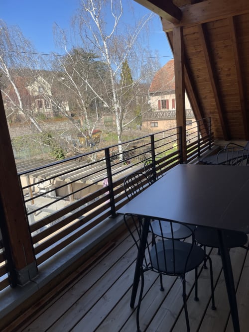 Terrasse avec table et chaises de dining offrant une vue sur le village de Ribeauvillé, bouleaux nus et bâtisses alsaciennes traditionnelles