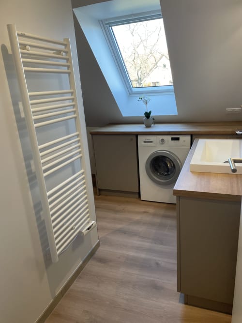 Buanderie moderne de l'appartement La clé des vignes avec machine à laver, sèche-serviettes chauffant et puits de lumière