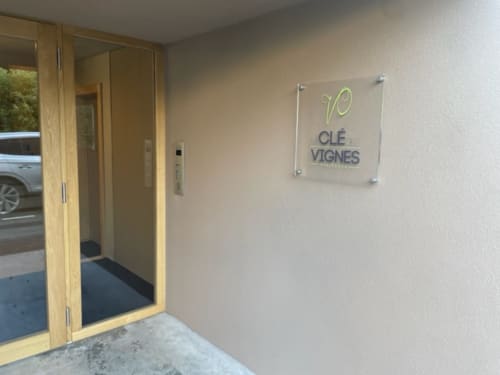 Entrée de l'appartement La clé des vignes à Ribeauvillé avec porte vitrée moderne et signalisation