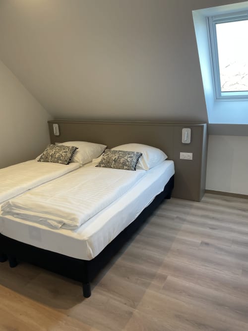 Chambre moderne de l'appartement La clé des vignes à Ribeauvillé, avec lit double, vue sur jardin et design contemporain