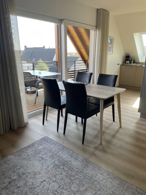 Espace de dining moderne avec accès à la terrasse de l'appartement La clé des vignes à Ribeauvillé, vue sur le jardin et style contemporain