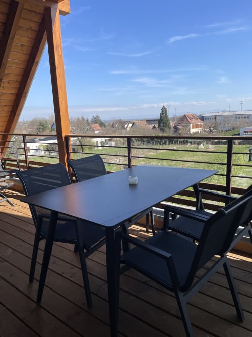 Terrasse de La clé des vignes à Ribeauvillé avec tables, chaises et vue sur les vignobles