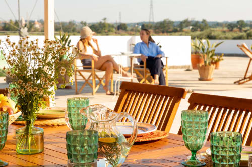 Terrazza di Villa Ceci ad Andria con vista sul waterfront, allestimento per cena e ospiti che godono del paesaggio
