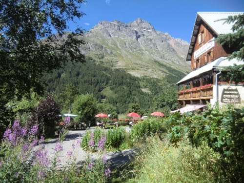 Hôtel Auberge du Pont de l'Alp au Monêtier-les-Bains avec montagnes alpines, fleurs du jardin et terrasse