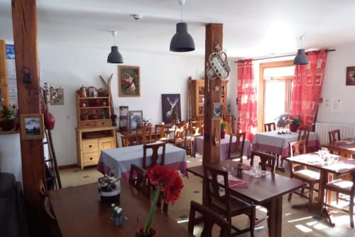 Salle à manger de l'Auberge du Pont de l'Alp avec mobilier en bois, accents rouges et décoration montagnarde à Le Monêtier-les-Bains
