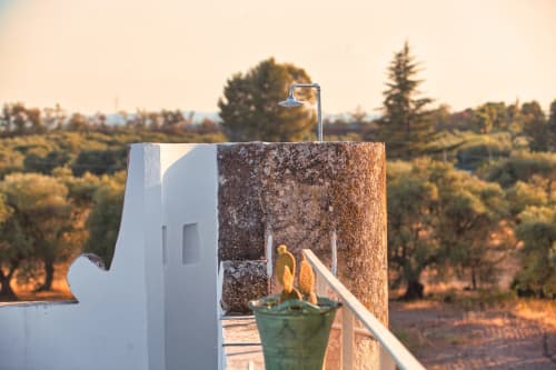 Torre in pietra rustica con ingresso bianco a Villa Ceci B&B ad Andria, Italia, affacciata sulla campagna