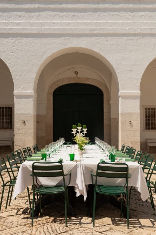 Lungo tavolo da pranzo all'aperto con sedie verdi a Villa Ceci ad Andria, Italia