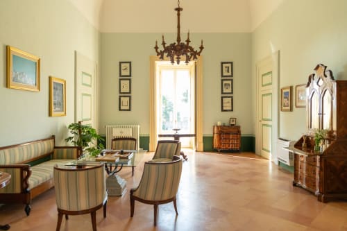 Elegante soggiorno di Villa Ceci, Andria con mobili a righe, lampadario e pareti verdi