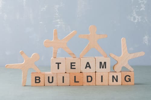 Figurines en bois et blocs formant 'TEAM BUILDING' à la Maison Terre de Lune B&B à Mondragón, France
