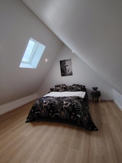 Chambre minimaliste mansardée au gîte Skol en Normandie avec velux, literie à motifs et parquet