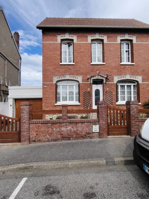 Chaumière en briques rouges aux fenêtres à encadrement blanc à Dieppe, Normandie, avec garage blanc et mur de briques à l'entrée