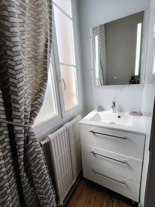 Vasque moderne blanche avec miroir LED au gîte Skol In Normandy à Rouen, lumière naturelle de la fenêtre