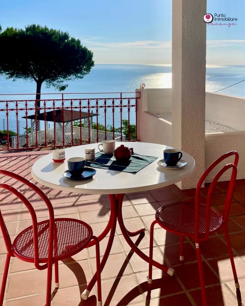Red chairs and white table with coffee setup on terrace overlooking sea, Villa Nella in Lanciano with Mediterranean view
