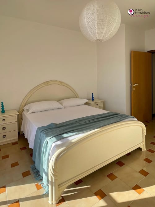 Elegant bedroom in Villa Nella, WelcHome hotel, Lanciano with cream bed, white bedding, sea view, and terracotta tile floor