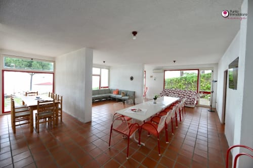 Villa Nella dining area in Lanciano with red chairs, sea views, and outdoor access