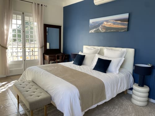Chambre cosy à La Closerie à La Redorte avec murs bleus, literie blanche, oreillers foncés et accès à terrasse privée