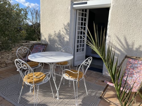 Terrasse privée de La Closerie avec mobilier blanc orné, vue sur le jardin et plante en pot à La Redorte