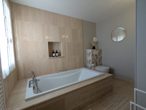 Salle de bain moderne à La Closerie B&B à La Redorte avec baignoire îlot, carrelage effet bois et miroir rond