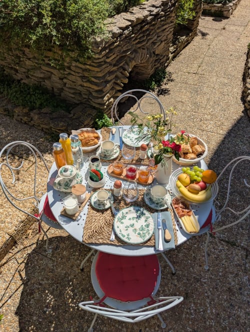 Table de petit-déjeuner en terrasse à La Closerie B&B à La Redorte, avec viennoiseries, fruits frais et vue sur le jardin privé
