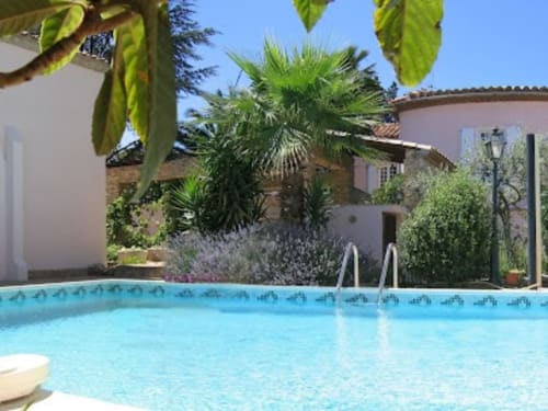 La piscine de La Closerie B&B avec palmiers, transats et bâtisses blanchies à la chaux à La Redorte, France