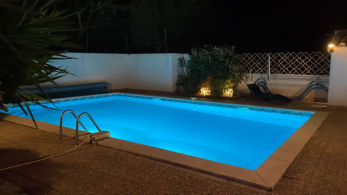 Piscine rectangulaire illuminée la nuit avec éclairage LED bleu à La Closerie, gîte à La Redorte, France