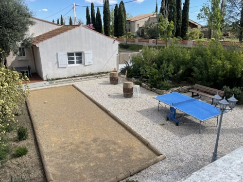 Vue du jardin à La Closerie B&B à La Redorte avec terrain de pétanque, table de ping-pong et chaumière blanche