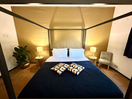 Chambre accessible à la La Fornace B&B à Alessandria avec lit à baldaquin, mur d'accent doré et mobilier moderne