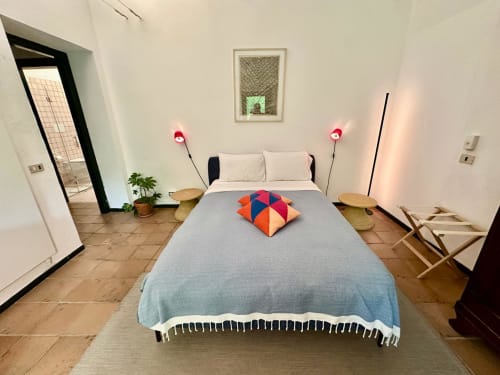 Chambre moderne et accessible à La Fornace B&B à Alexandrie avec un lit bleu, des coussins colorés et un éclairage ambiant