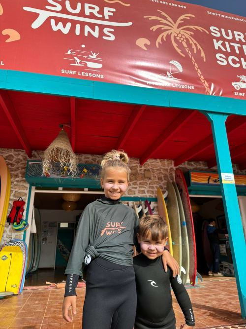Deux enfants en combinaisons de surf à l'école Surf Twins, El Ghazouane, Maroc près du Riad Eucalyptus