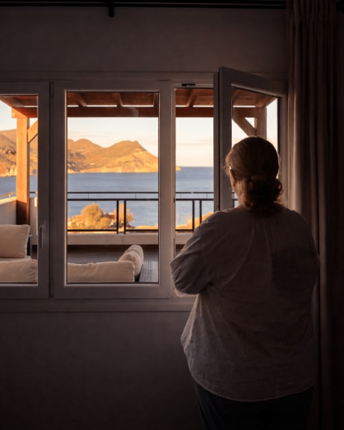 Huésped admirando la vista al mar Mediterráneo y las montañas desde el balcón del Apartamento 9 Deluxe en El Faro De Los Genoveses, Almería