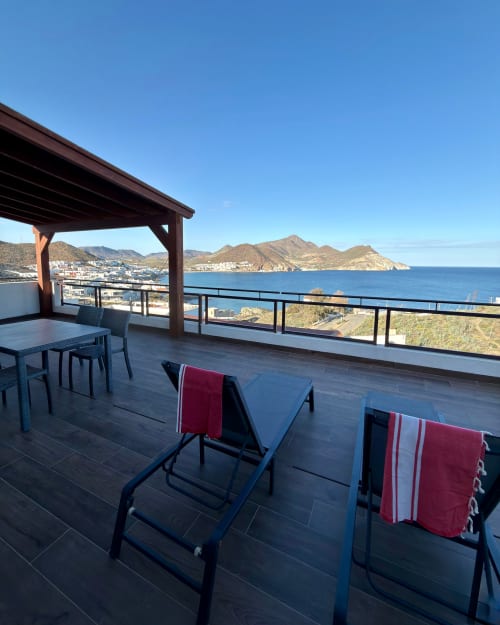 Terraza de lujo con vistas al mar en El Faro De Los Genoveses, San José Almería, con tumbonas y zona de comedor