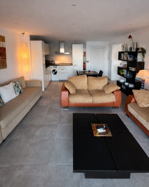 Salón moderno en Apartamento 9 Deluxe de El Faro De Los Genoveses, San José Almería, con sofás en tonos beige y terracota,