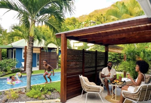 Family enjoying poolside patio at Mon'Désir Lodge cottage in Martinique with garden views and tropical surroundings