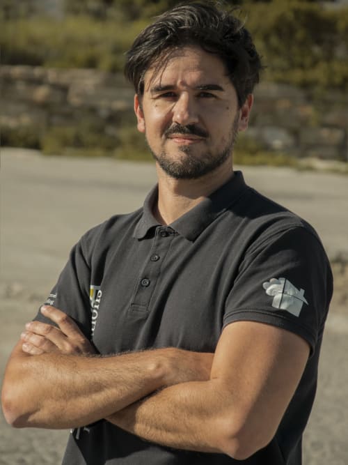 Miembro del personal masculino con los brazos cruzados vistiendo polo oscuro en el hotel Escanda Building Solutions en España