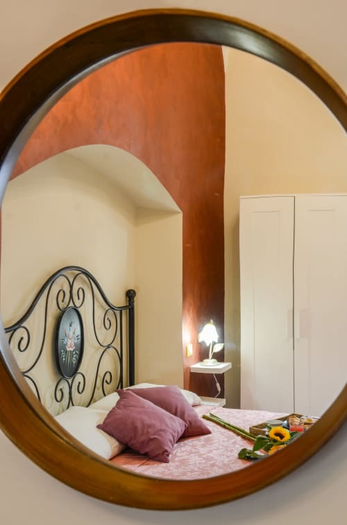 Riflesso circolare della camera da letto della Casa Scola B&B a Loano, Italia con letto dai cuscini viola