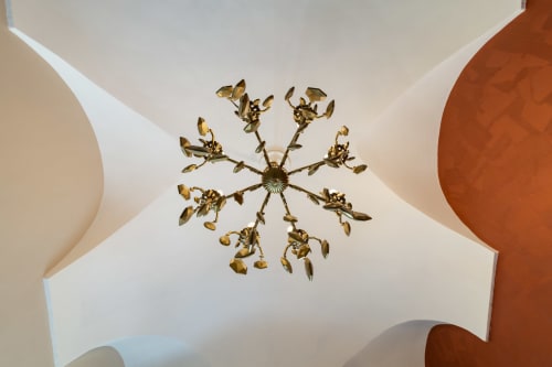 Lampadario decorativo in ottone a forma di sole sul soffitto bianco, Casa Scola B&B a Loano